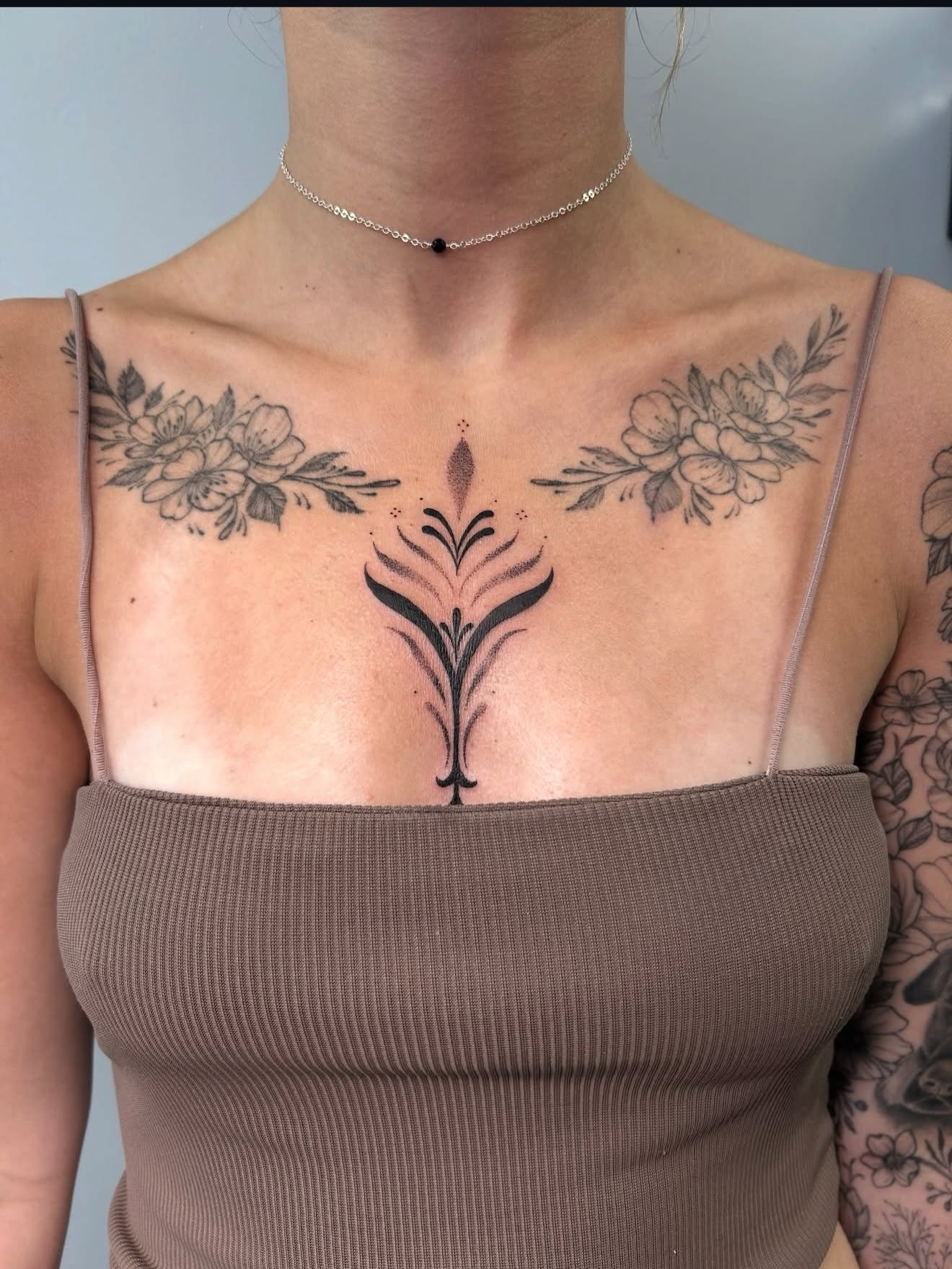 Fine line ornamental chest tattoo